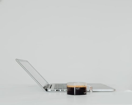 Minimalist office desk with laptop and coffee cup