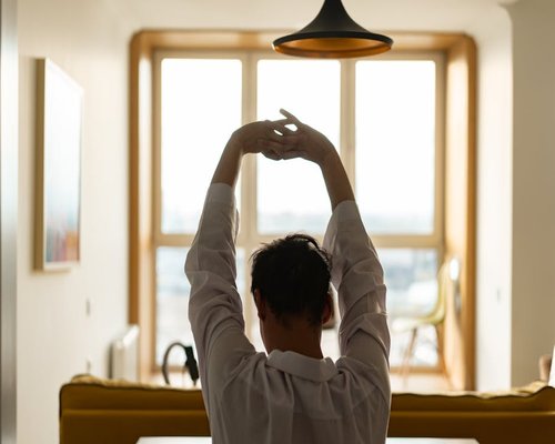 Person stretching near large office window with city view
